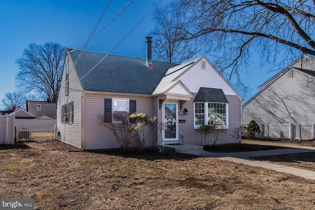 view of front of home with fence and roof with shingles