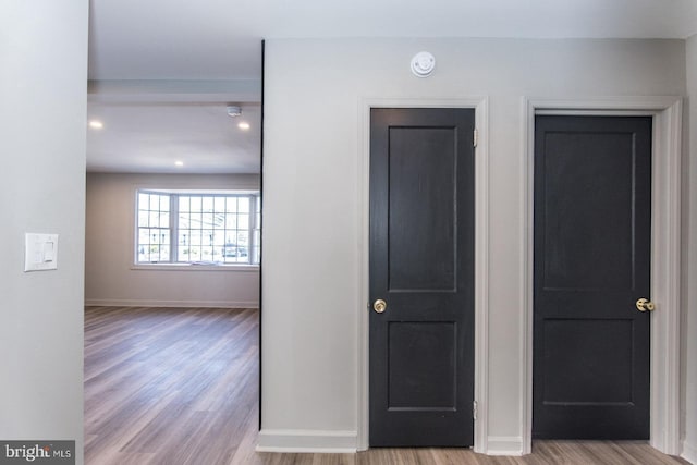 hall with baseboards and wood finished floors