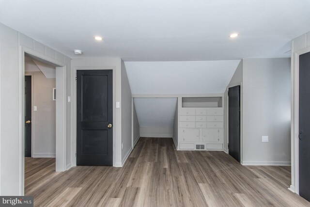 additional living space featuring recessed lighting, wood finished floors, and baseboards