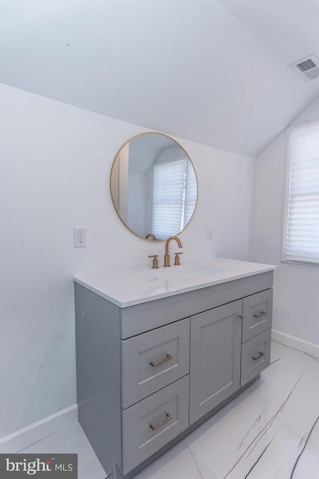 bathroom featuring lofted ceiling, baseboards, visible vents, and vanity