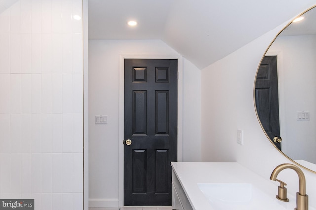 bathroom featuring recessed lighting, vaulted ceiling, and vanity