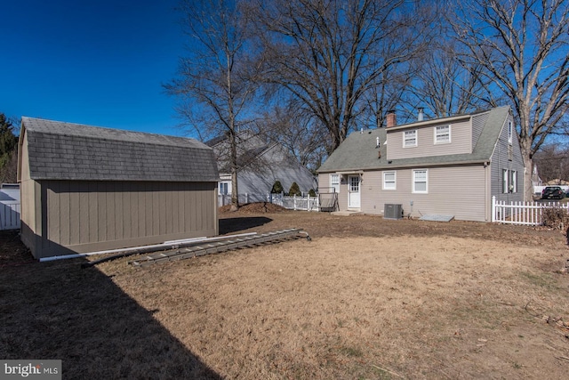 view of yard featuring a storage shed, an outbuilding, fence, and cooling unit