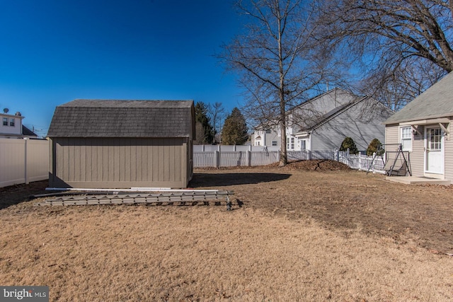 view of yard featuring a fenced backyard, an outdoor structure, and a storage shed