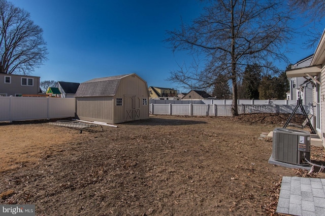 view of yard featuring an outbuilding, central AC, a shed, and a fenced backyard