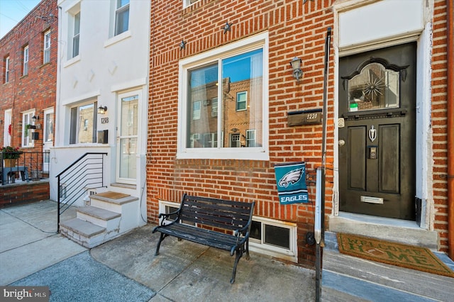 view of exterior entry featuring brick siding