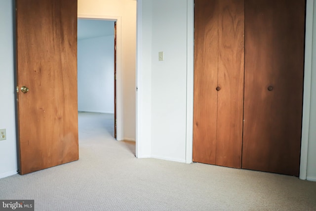 unfurnished bedroom with carpet floors, a closet, and baseboards