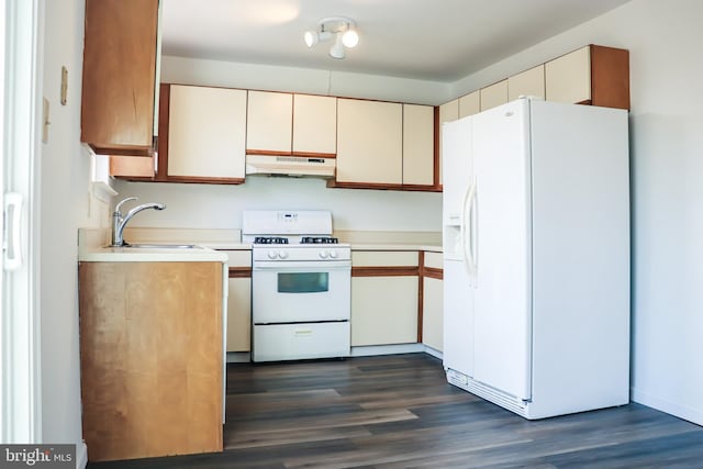 kitchen with dark wood-style floors, light countertops, a sink, white appliances, and under cabinet range hood