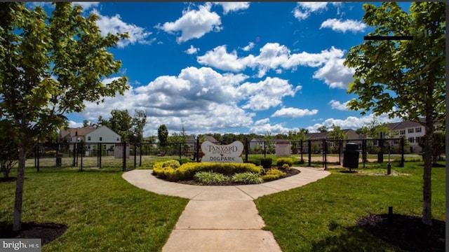 view of property's community featuring fence and a lawn