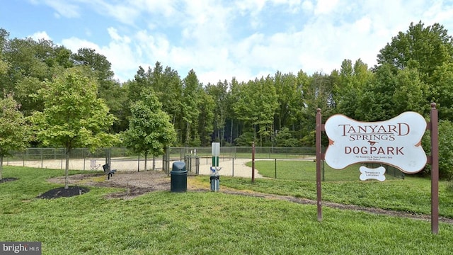 view of property's community featuring a yard and fence