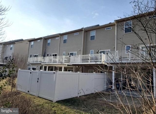 back of house featuring fence and a deck