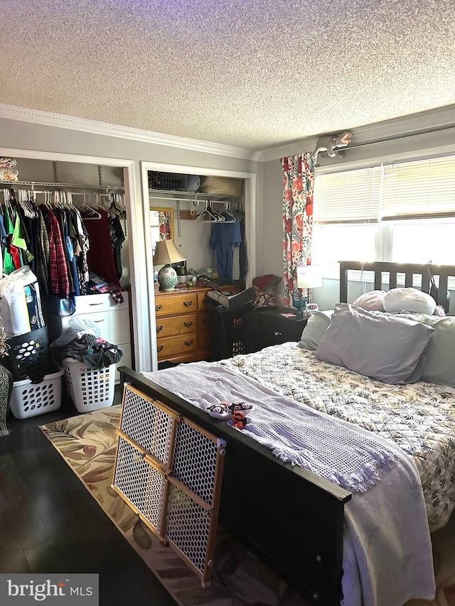 bedroom with a textured ceiling and two closets