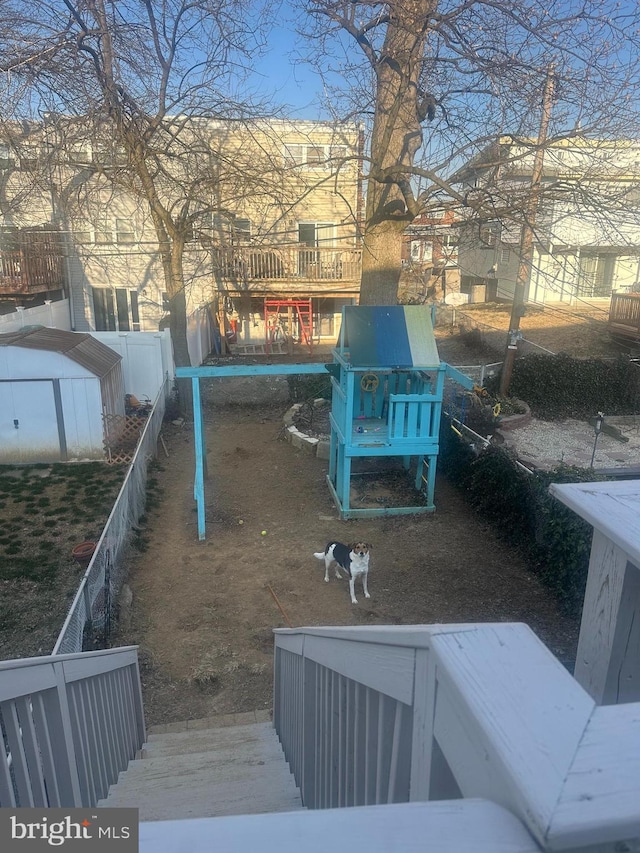 view of yard featuring a shed, fence, and an outdoor structure