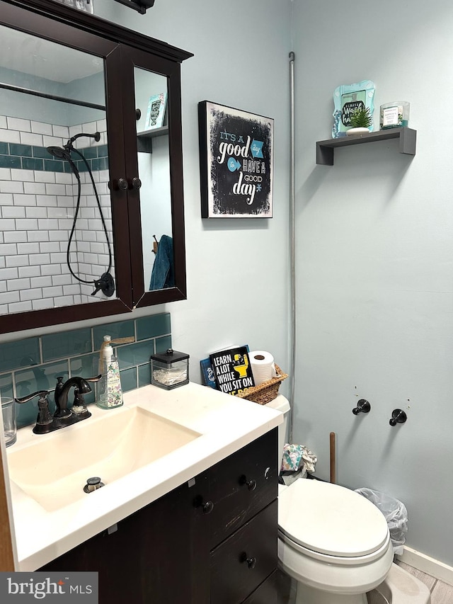 bathroom featuring toilet, tasteful backsplash, and vanity