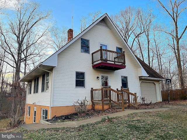 view of front facade with a chimney and a balcony