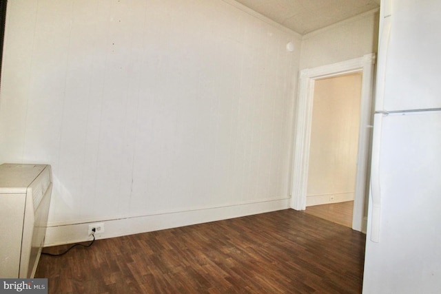 spare room featuring ornamental molding and wood finished floors