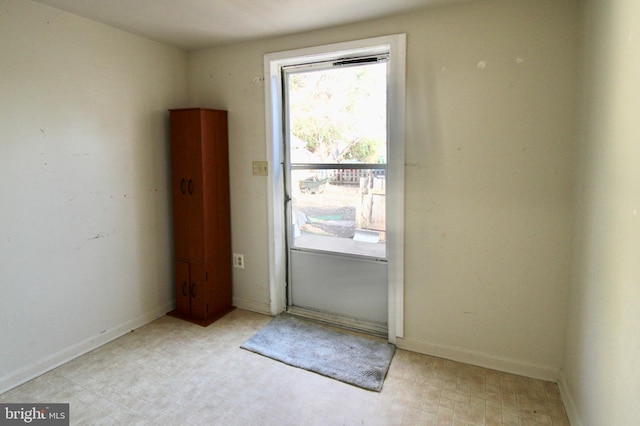 doorway featuring tile patterned floors and baseboards