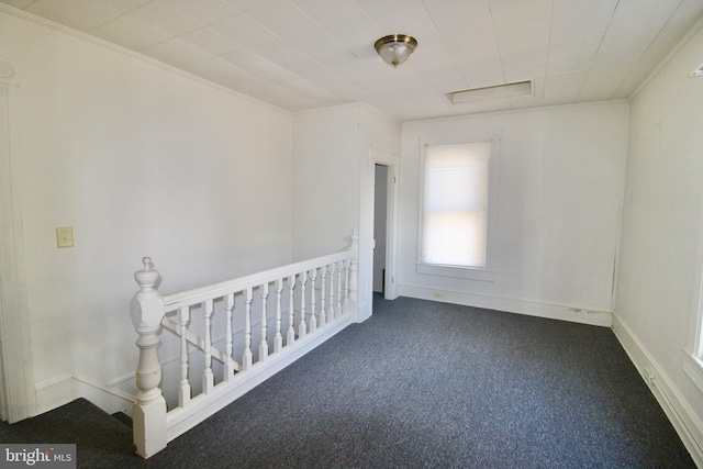 unfurnished room featuring baseboards and dark colored carpet