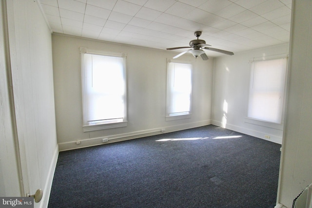 carpeted spare room featuring ceiling fan and baseboards