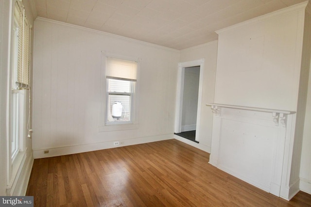 empty room with crown molding and wood finished floors