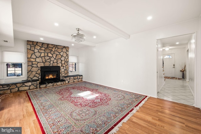 living area with recessed lighting, a fireplace, beam ceiling, and wood finished floors