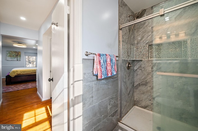 ensuite bathroom with ensuite bathroom, a stall shower, and wood finished floors