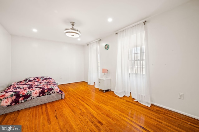 unfurnished bedroom with baseboards, wood finished floors, and recessed lighting