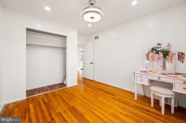 unfurnished bedroom featuring recessed lighting, parquet flooring, visible vents, baseboards, and a closet