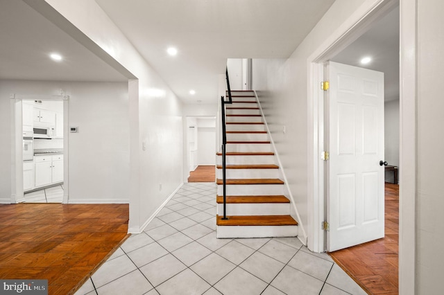 stairway with recessed lighting, baseboards, and tile patterned floors