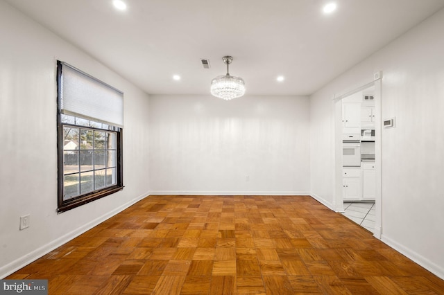 empty room featuring recessed lighting, visible vents, a notable chandelier, and baseboards