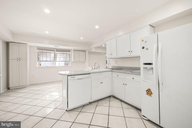 kitchen featuring white appliances, light tile patterned flooring, a sink, and white cabinetry