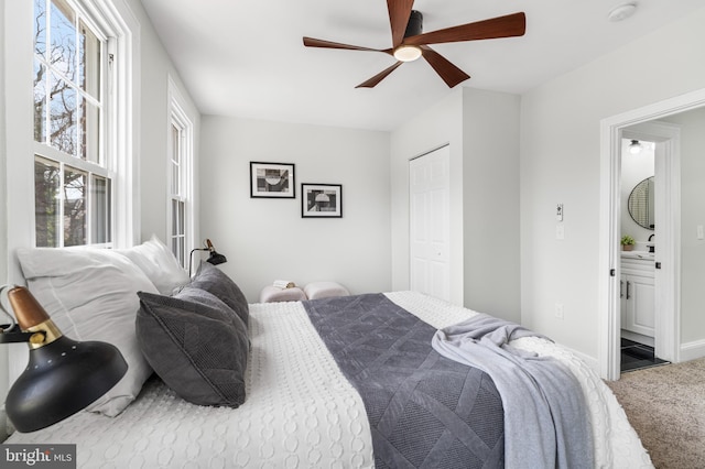 carpeted bedroom with ceiling fan, a closet, and baseboards