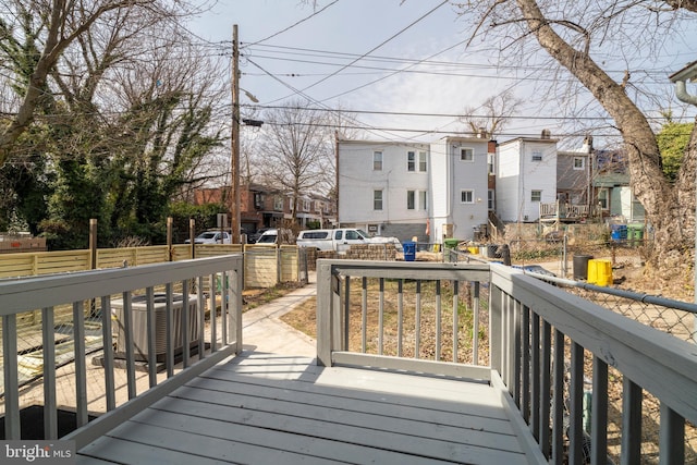 wooden terrace with a residential view, central AC, and fence