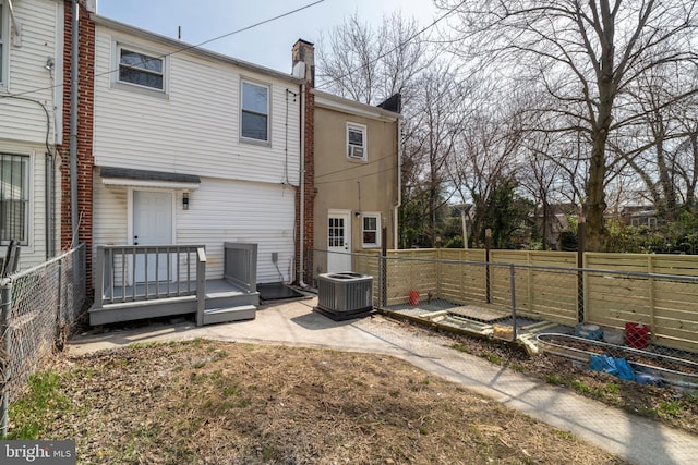 rear view of house with central AC, a chimney, a patio, and a fenced backyard