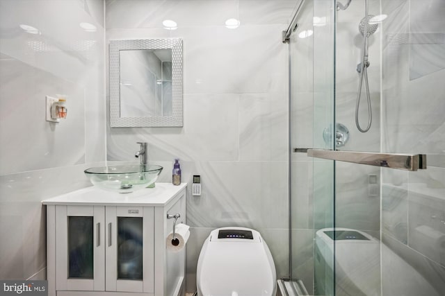 full bathroom with toilet, a stall shower, vanity, and tile walls