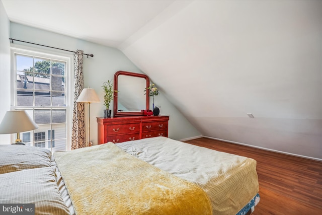 bedroom featuring lofted ceiling and wood finished floors