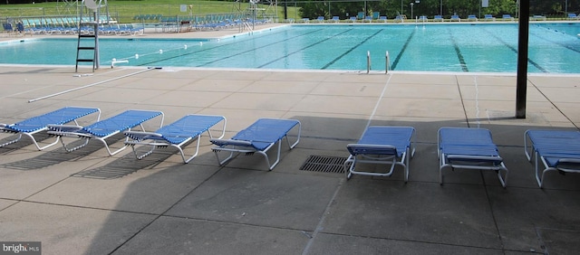 pool with a patio area and fence