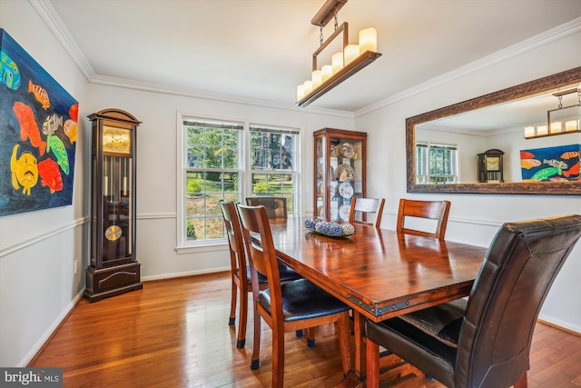 dining space with crown molding, baseboards, and hardwood / wood-style flooring