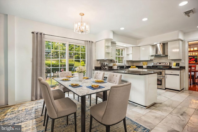 kitchen with open shelves, dark countertops, visible vents, wall chimney range hood, and double oven range