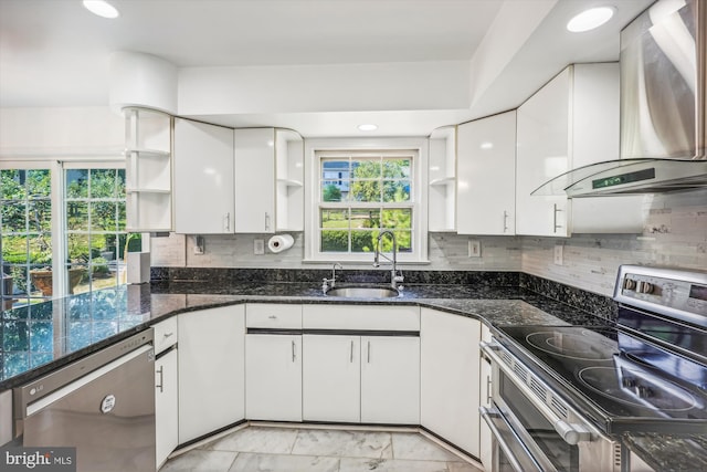 kitchen with open shelves, appliances with stainless steel finishes, wall chimney exhaust hood, and a sink