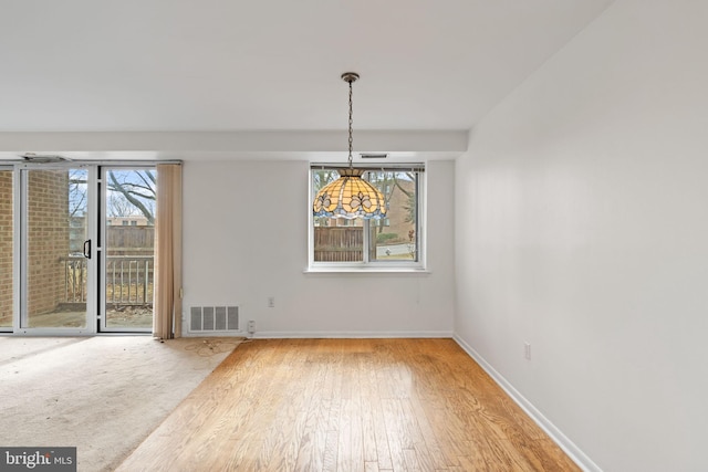 unfurnished dining area featuring visible vents, baseboards, and wood finished floors