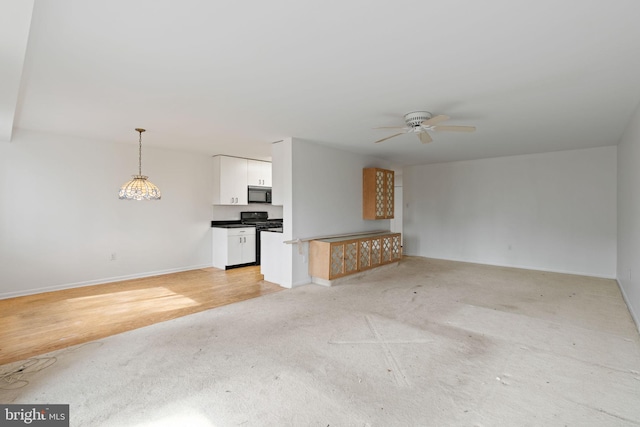 unfurnished living room featuring a ceiling fan and baseboards