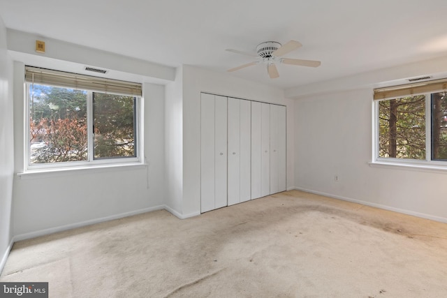 unfurnished bedroom featuring a closet, multiple windows, baseboards, and carpet flooring