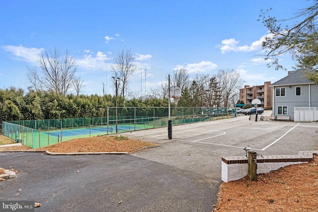 view of basketball court with a tennis court, community basketball court, and fence