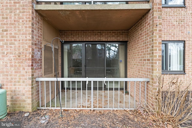 doorway to property featuring brick siding