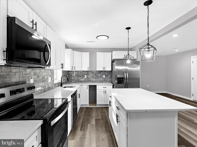 kitchen with dark wood-style floors, backsplash, appliances with stainless steel finishes, a kitchen island, and a sink