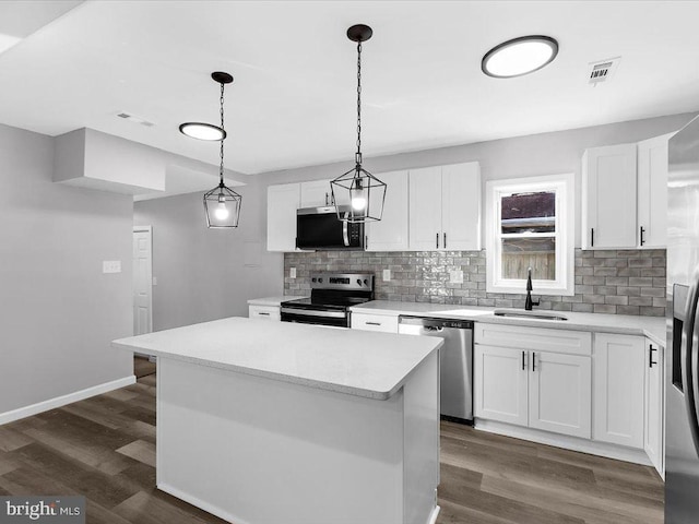 kitchen featuring stainless steel appliances, dark wood-type flooring, a sink, and visible vents