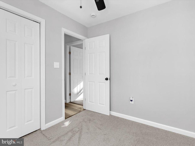 unfurnished bedroom featuring carpet, baseboards, ceiling fan, and a closet