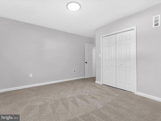 unfurnished bedroom with baseboards, a closet, visible vents, and carpet flooring