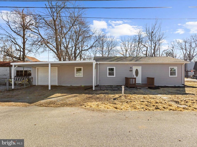 ranch-style home featuring a garage, driveway, and a carport