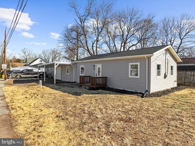 view of front facade with a deck, a front lawn, and fence